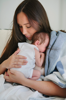 baby resting on her mum after breastfeeding