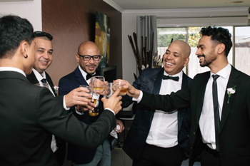 Groomsmens with glasses on their handscheering