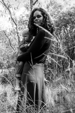 mother and son standing in the trees