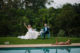 bride and groom sitting around the pool with Champagne