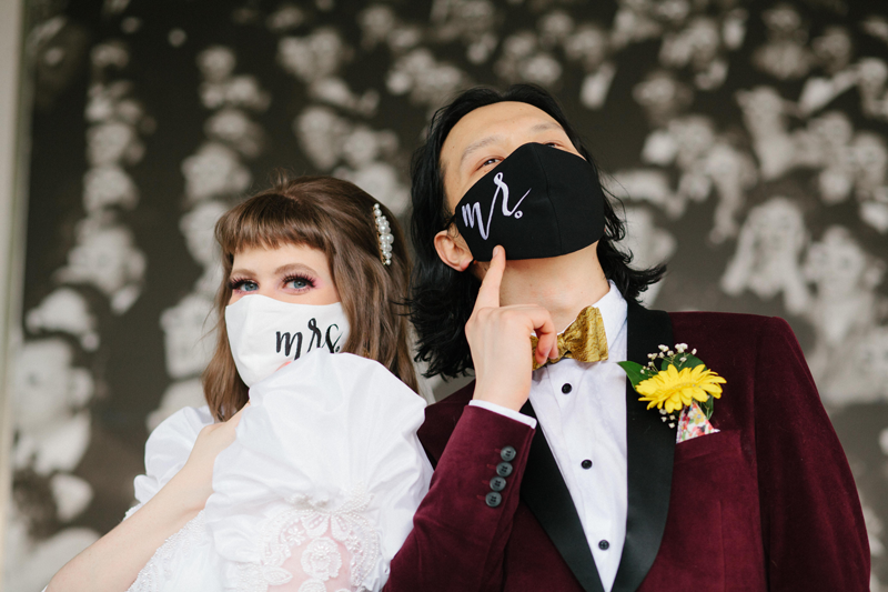 wedding portrait of a bride and groom wearing a mask