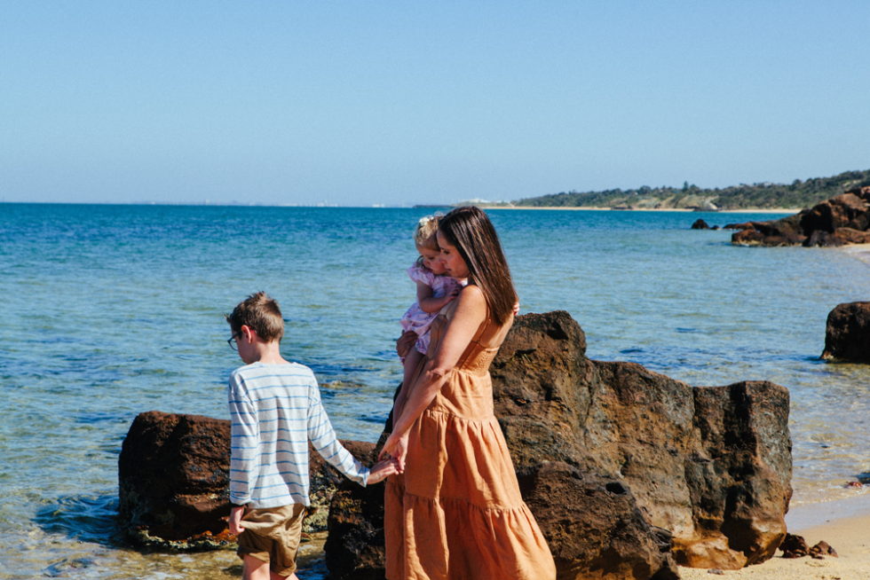 mum and kids walking at the beach