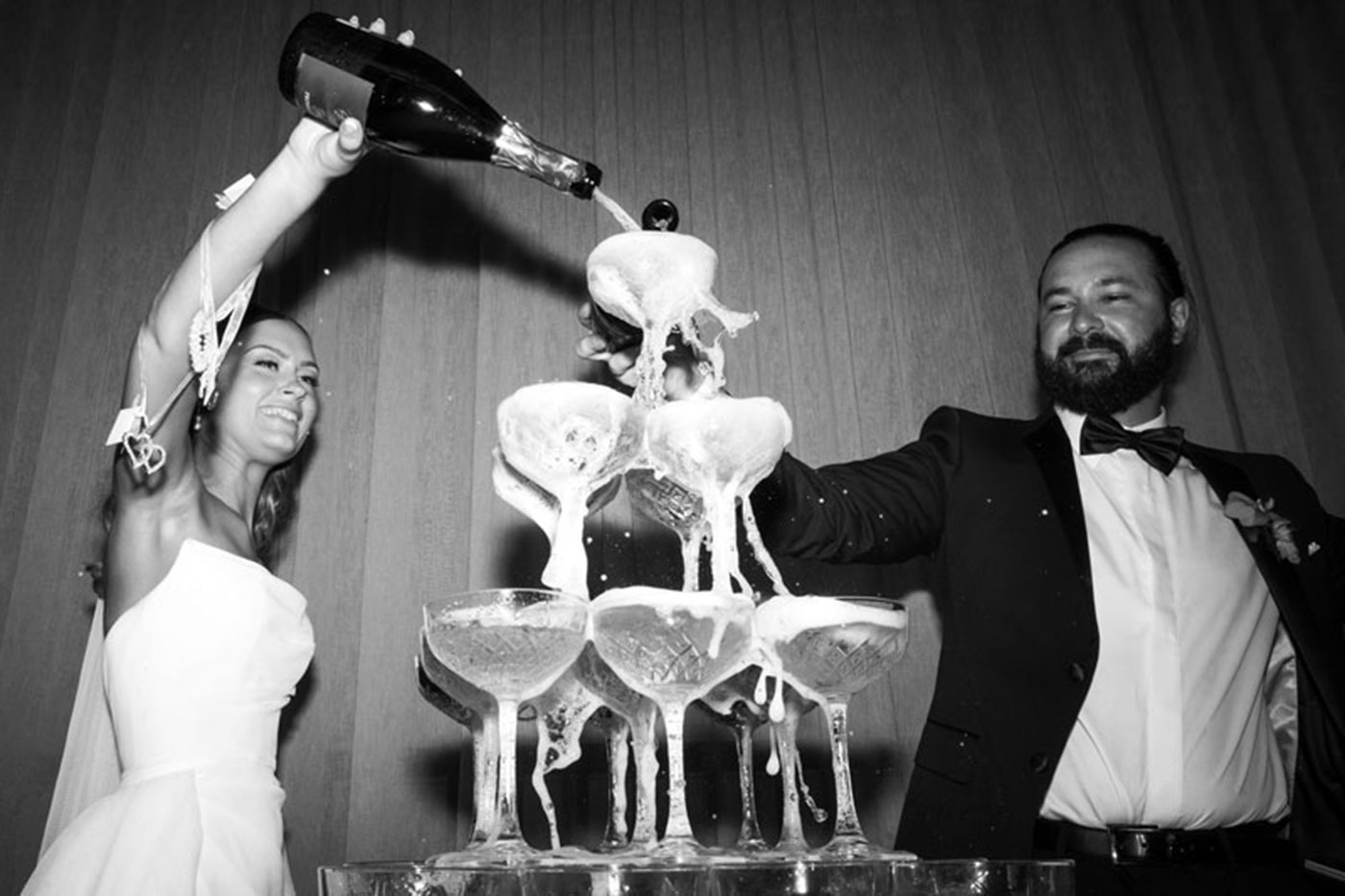 The bride and groom poured champagne into a champagne tower.